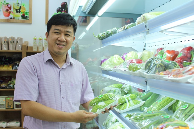 nh Võ Thành Hòa bên sản phẩm rau hướng hữu cơ ở cửa hàng thực phẩm Naganic.